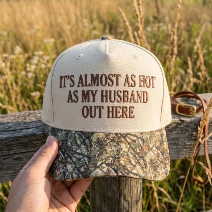 Front view of cream and camouflage hat with embroidered husband joke