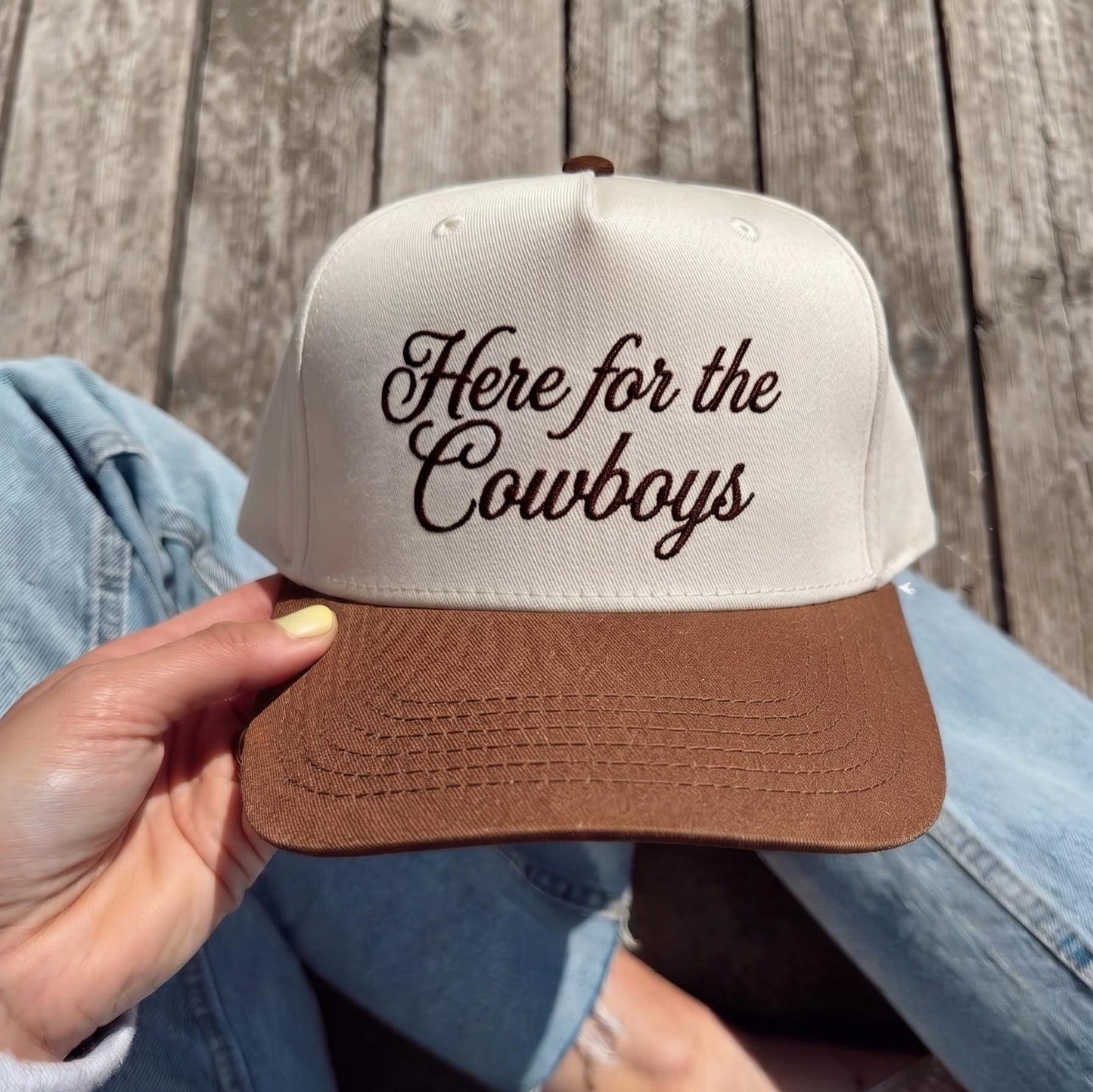 Here for the Cowboys embroidered cap with white crown and brown brim on a wooden deck