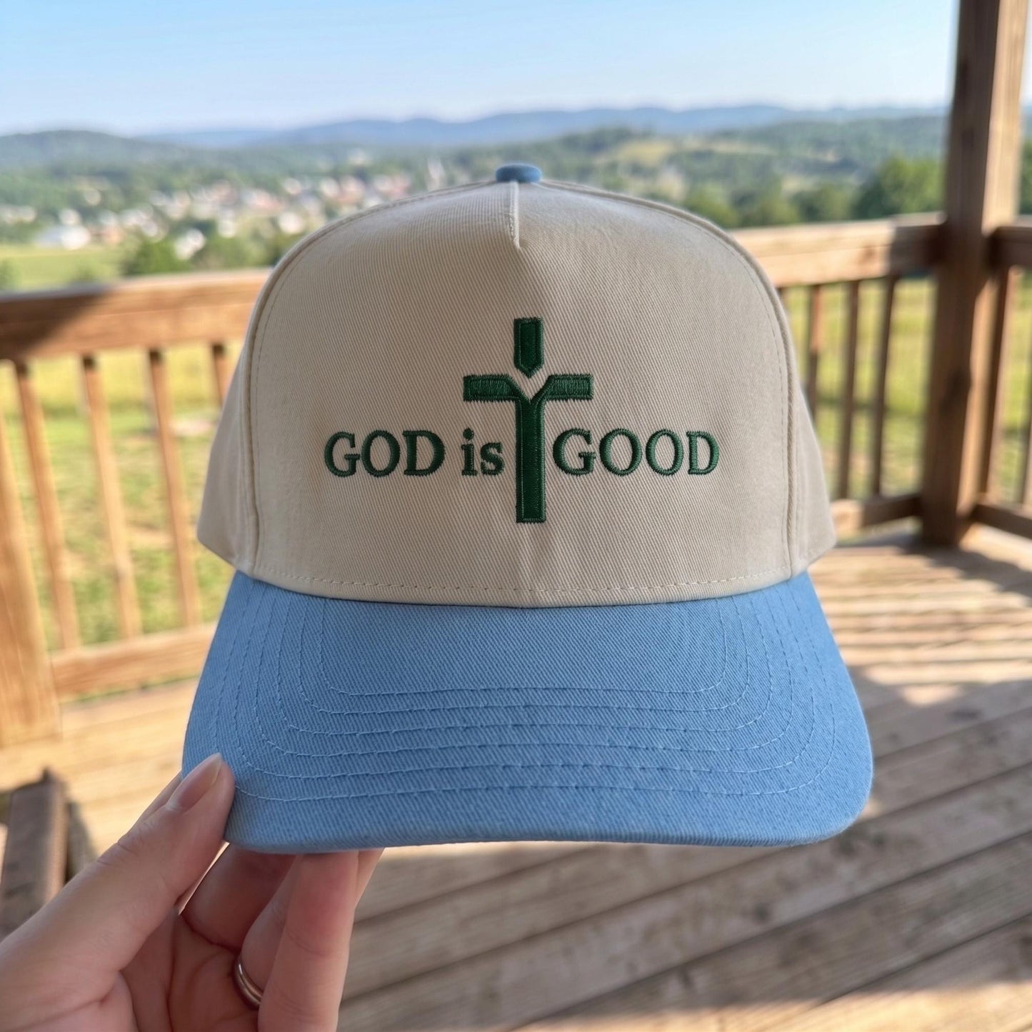Inspirational trucker hat with 'God is Good' cross design, cream and blue color