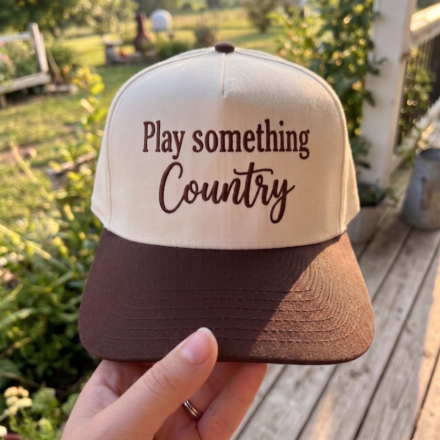 Country music themed trucker hat with 'Play Something Country' design in cream and brown colors