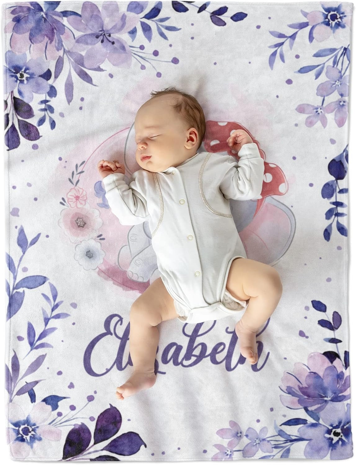Adorable baby girl sleeping peacefully on a personalized elephant baby blanket with floral design and the name Elizabeth