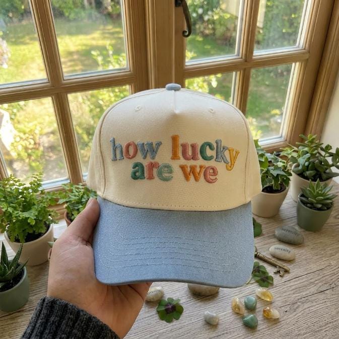 Two-tone embroidered trucker cap with colorful how lucky are we lettering