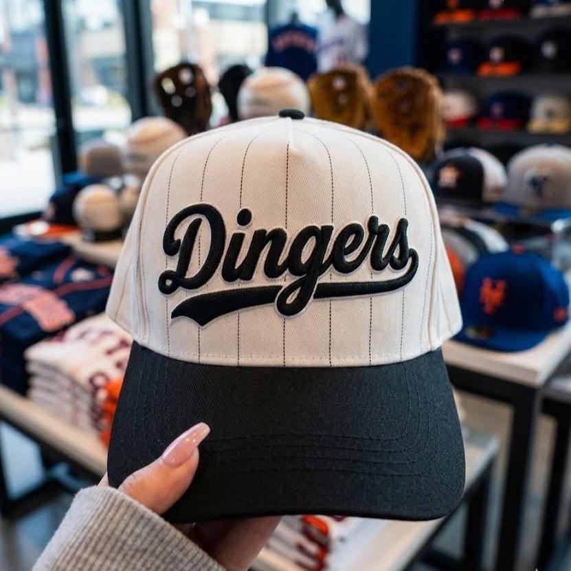 White pinstripe baseball hat with black brim and embroidered Dingers script