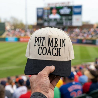 Put Me In Coach pinstripe baseball hat held at a baseball stadium