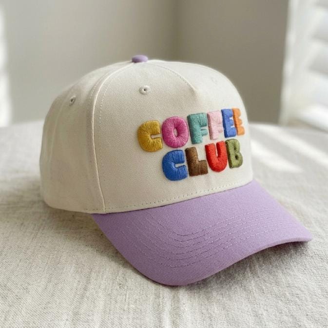 Angled view of two-tone cream and lavender Coffee Club embroidered cap