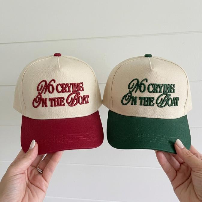 Two-tone trucker hats embroidered with No Crying on the Boat in burgundy and forest green