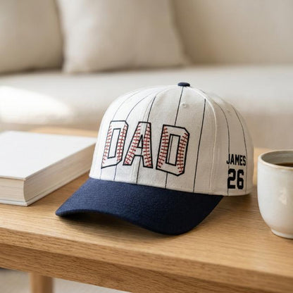 DAD pinstripe hat displayed on a wooden table beside a book and coffee