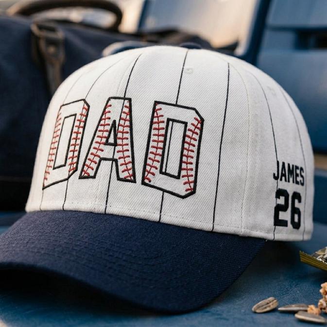 Close-up of DAD baseball hat lettering with red stitch-style accents and James 26 side detail
