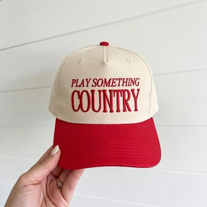 Cream and red two-tone trucker cap with Play Something Country embroidery