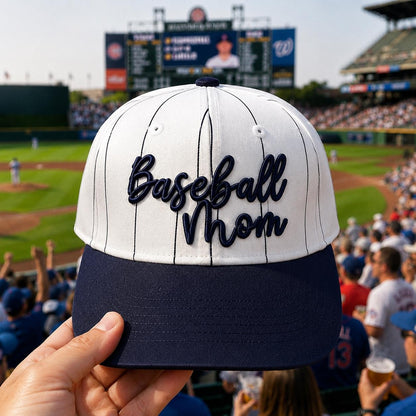 Front view of a white pinstripe hat embroidered with Baseball Mom lettering and a navy bill