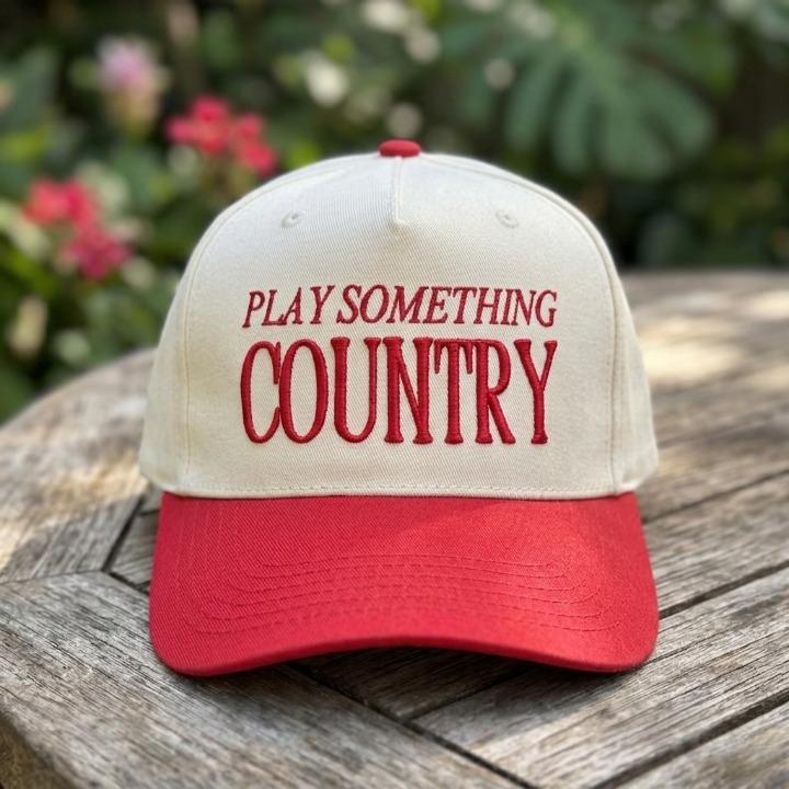Front view of Play Something Country embroidered trucker cap outdoors
