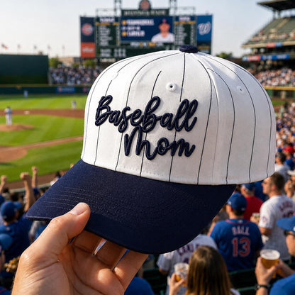 White pinstripe baseball mom hat with raised navy script embroidery at a baseball stadium