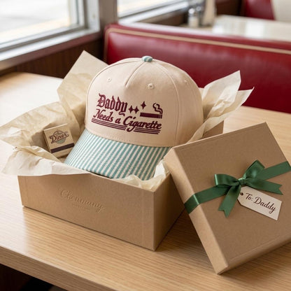 Embroidered khaki hat with light blue striped bill presented in a gift box