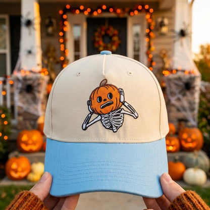 Two-tone cream and light blue hat with embroidered pumpkin skeleton design