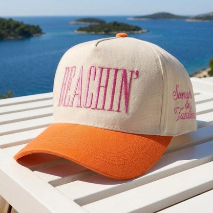 Beachin’ embroidered two-tone trucker cap displayed against a blue coastal seascape
