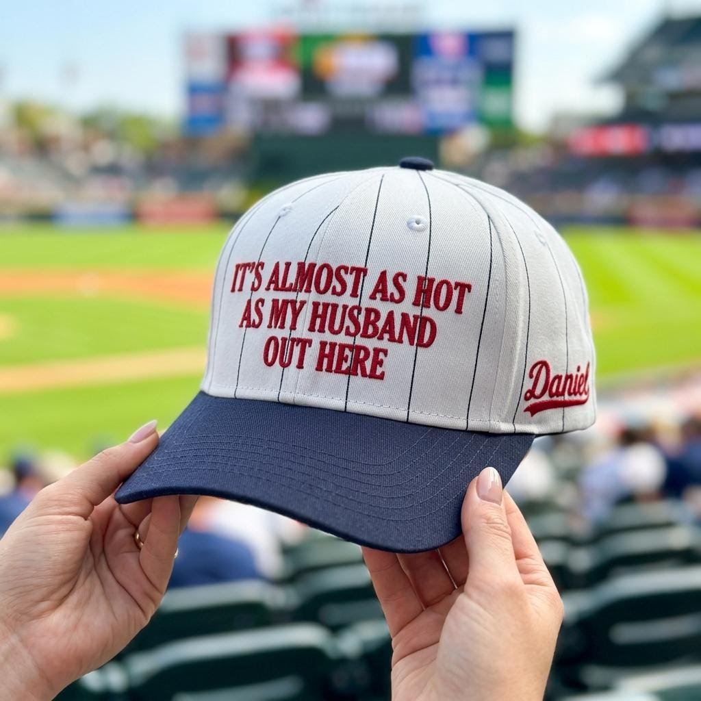 Funny pinstripe baseball hat held in front of a baseball stadium