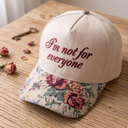 Angled view of embroidered “I’m not for everyone” hat on a wooden table