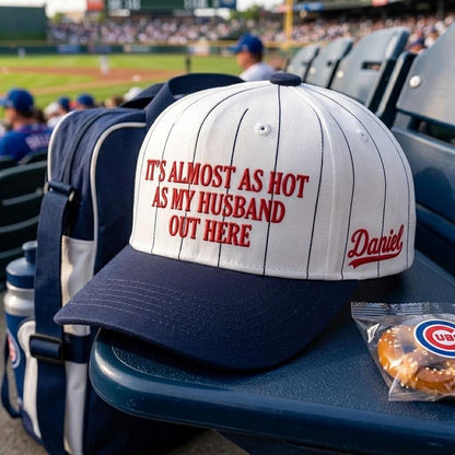 White and navy humorous husband-themed hat displayed in stadium seating