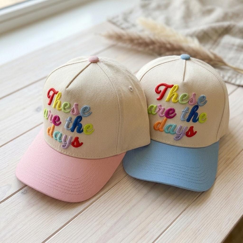 Side view of two neutral crown hats with colorful brims and These are the days embroidery