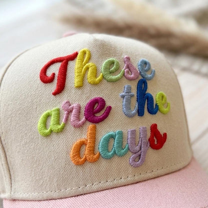 Close-up of colorful raised embroidery reading These are the days on a two-tone hat