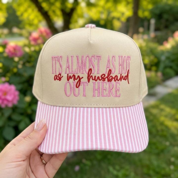 Red striped brim hat embroidered with “It’s Almost as Hot as My Husband Out Here”