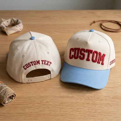 Light snapback hat with blue brim, raised custom text, and adjustable closure