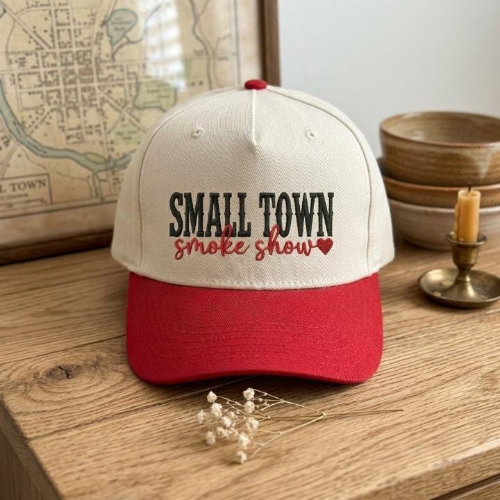 Small Town Smoke Show embroidered hat displayed on a wooden table