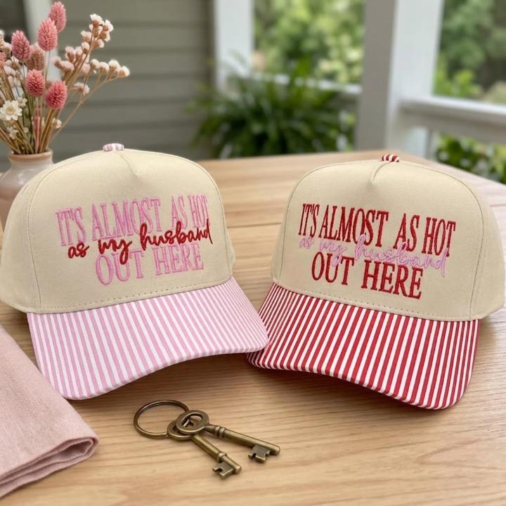 Pink striped brim hat embroidered with “It’s Almost as Hot as My Husband Out Here”
