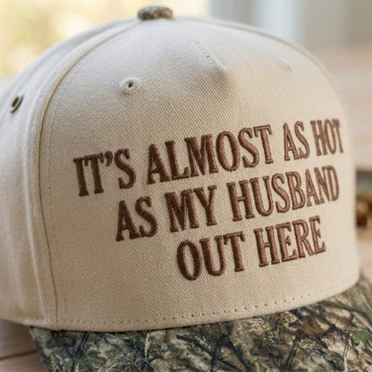 Embroidered text detail on cream and camouflage hat