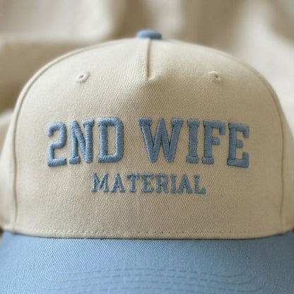 Close-up of the embroidered 2ND WIFE MATERIAL lettering on the hat