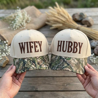 Matching Wifey and Hubby trucker hats with cream crowns and camouflage-patterned bills