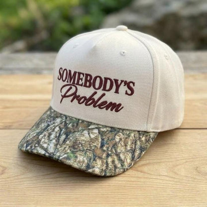 Angled view of embroidered Somebody’s Problem hat with camouflage bill