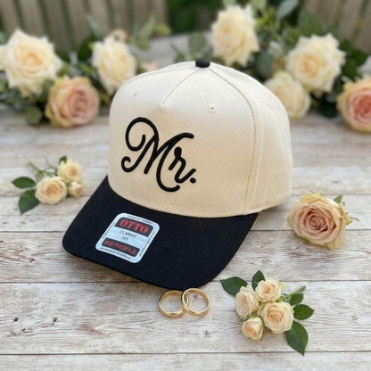 Cream and black Mr. embroidered trucker hat shown at an angle