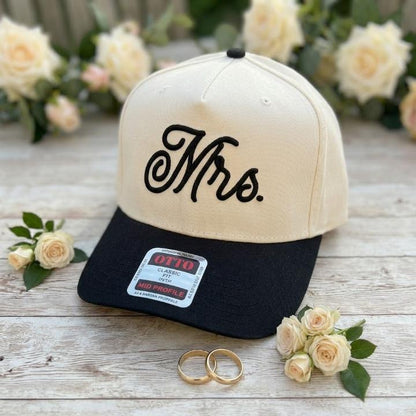 Cream and black Mrs. embroidered trucker hat shown with roses