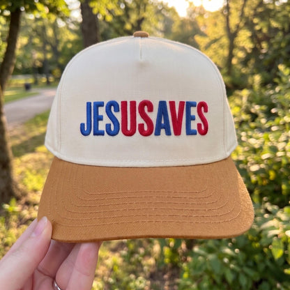 Embroidered JESUS SAVES cap with white crown, tan brim, and red and blue text