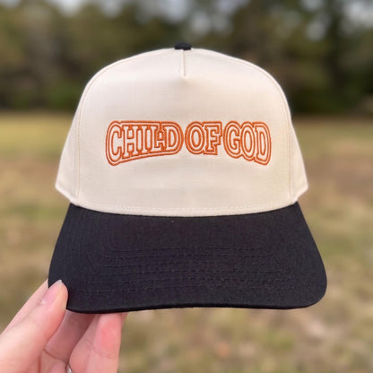 Vintage-style beige and black trucker hat with 'Child of God' embroidered in orange