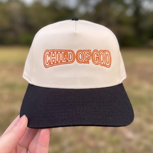Vintage-style beige and black trucker hat with 'Child of God' embroidered in orange