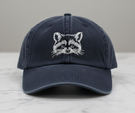 Raccoon embroidered navy cap with unique animal design and adjustable fit displayed on marble table