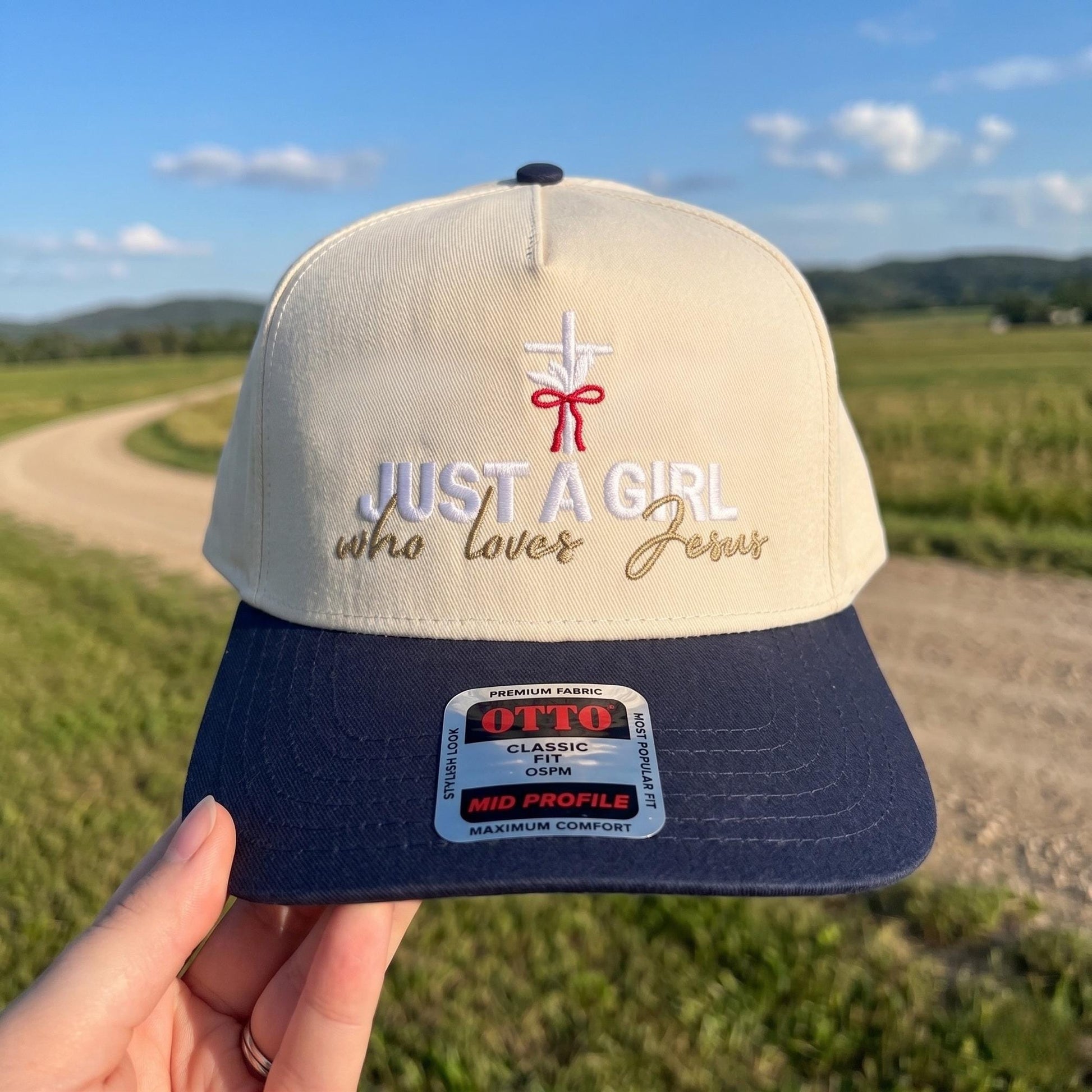 Inspirational baseball cap with 'Just a Girl Who Loves Jesus' embroidery in cream and navy colors