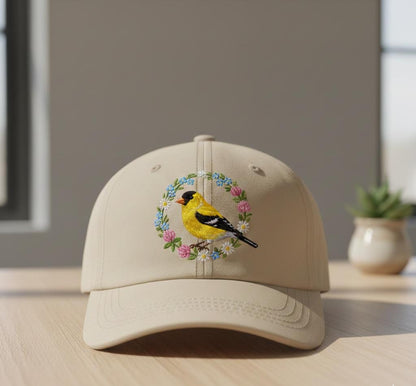 Embroidered baseball cap with goldfinch and floral design on beige fabric