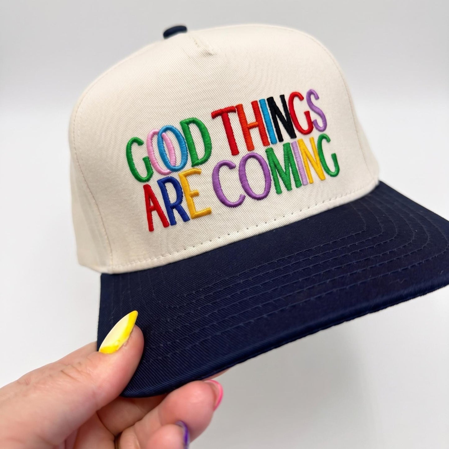 Good Things Are Coming' embroidered baseball cap with colorful text and navy brim