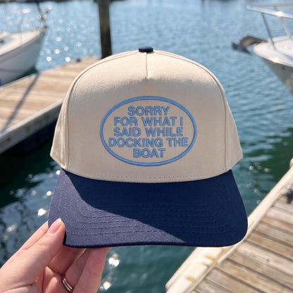 Navy and beige cap with humorous embroidery 'Sorry for What I Said While Docking the Boat' on dock setting
