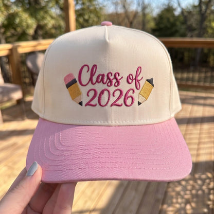 Class of 2026 graduation cap with pink brim and embroidered text