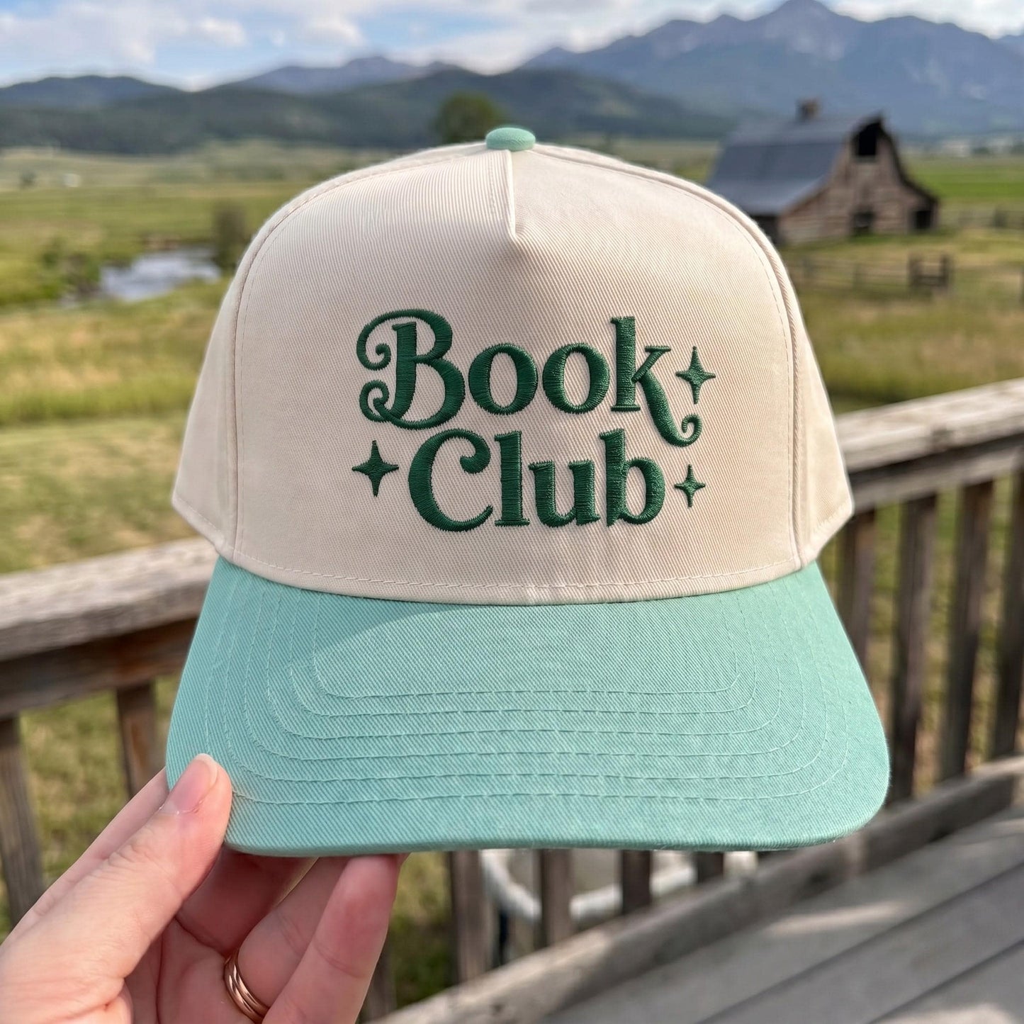 Book Club' embroidered beige and green cap with mountains backdrop