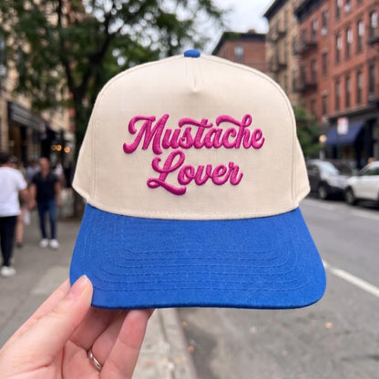 Mustache Lover cap with beige crown and blue brim featuring pink embroidery