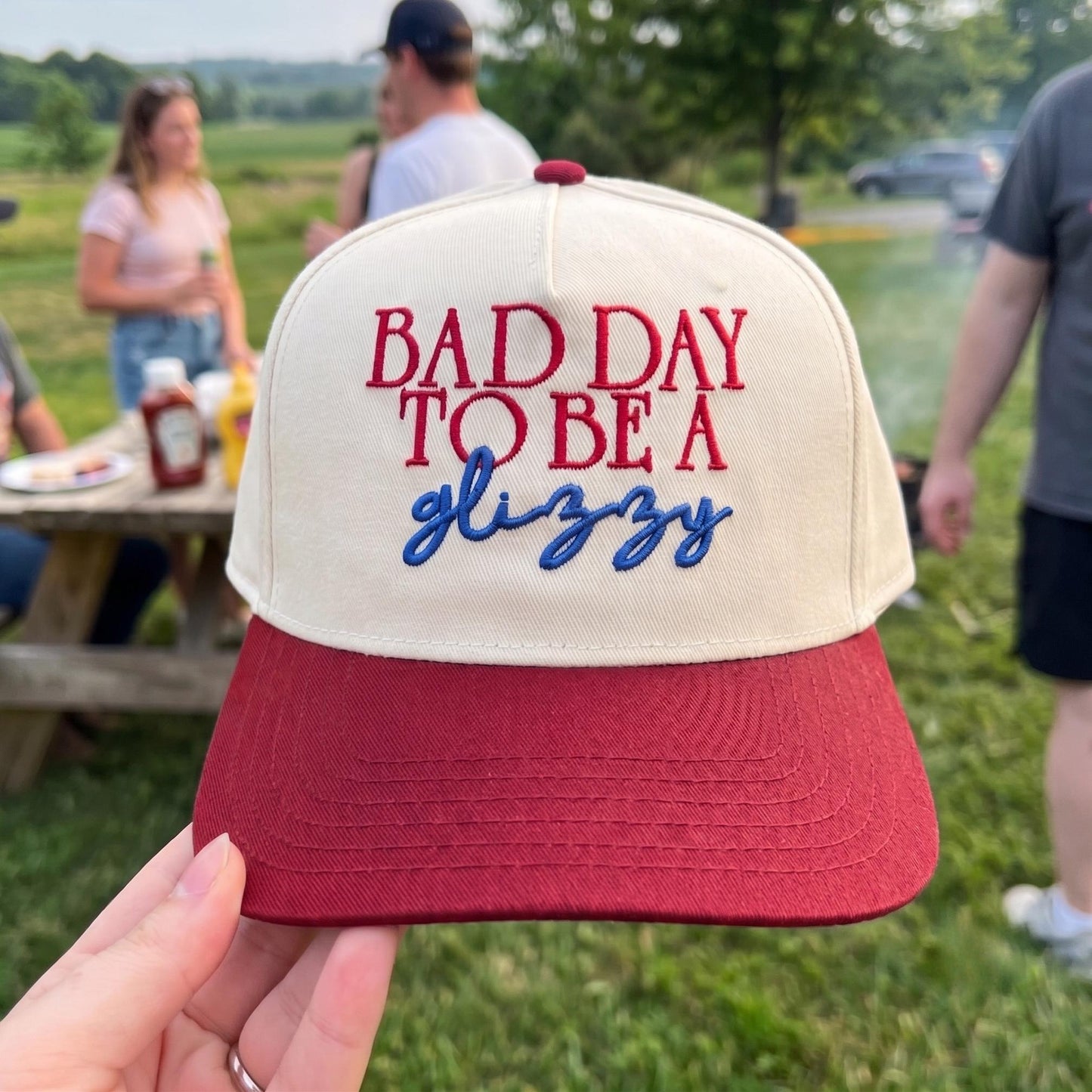 Novelty embroidered cap with 'Bad Day to Be a Glizzy' quote in red and blue stitching on a red and white background