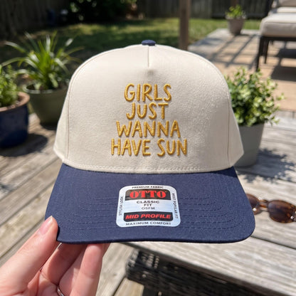 Trendy sun catching cap with fun embroidery, cream and navy color, displayed outdoors